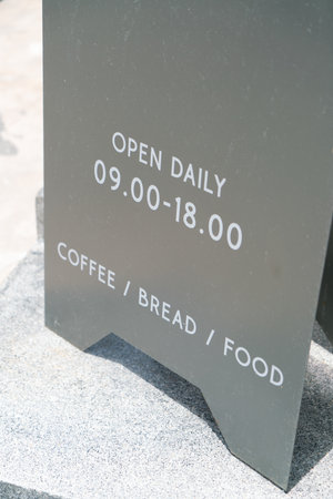 Text on a sign Open dialy on concrete floor in front of the coffee shopの写真素材