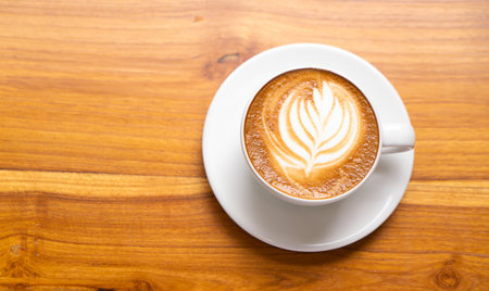 Hot Latte Coffee in a white cup on wooden table background.の写真素材