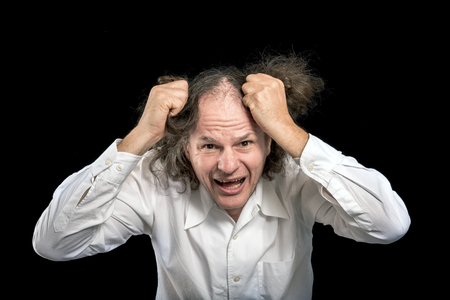 Man tearing his hair on a black backgroundの写真素材
