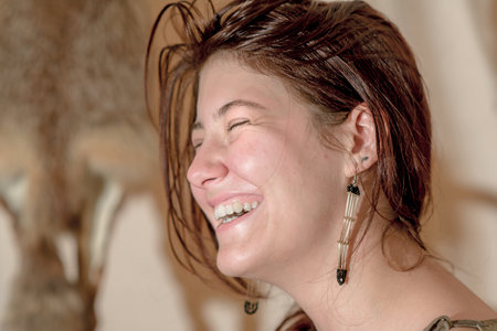 Portrait of a laughing young girl with closed eyes in profile