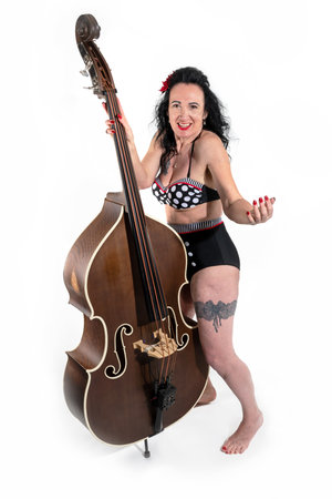 Sexy woman in bikini with a double bass on a white background in Studioの写真素材
