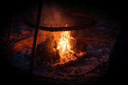 Bright burning fire with embers in front of black backgroundの写真素材
