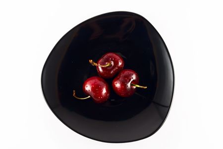 three cherries on a plateの写真素材