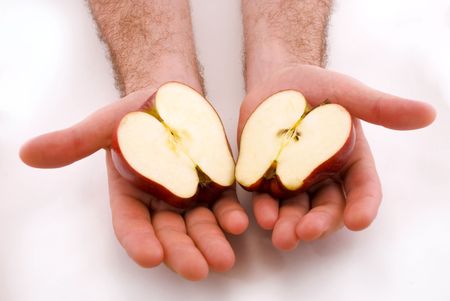 	 two halves of the apple in the hands ofの写真素材