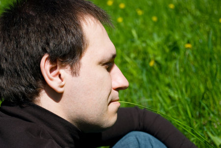 	 beautiful  young man sitting on the grass