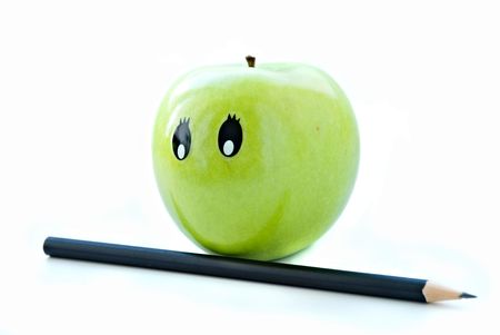 green apple with a face and a pencil on a white backgroundの写真素材