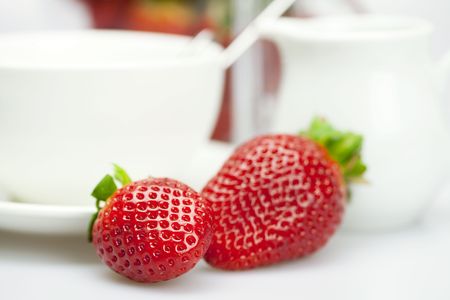 white cup and milk jug with strawberries isolated on whiteの写真素材