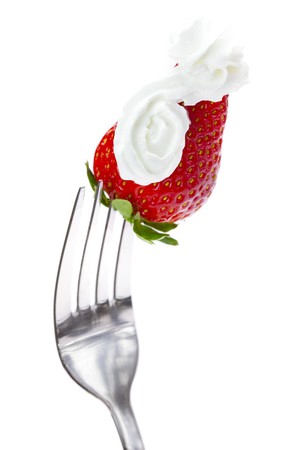 strawberries with cream on a fork isolated on whiteの写真素材