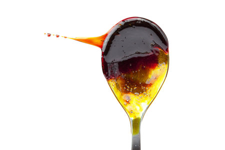 caramel flowing from the spoon isolated on whiteの写真素材