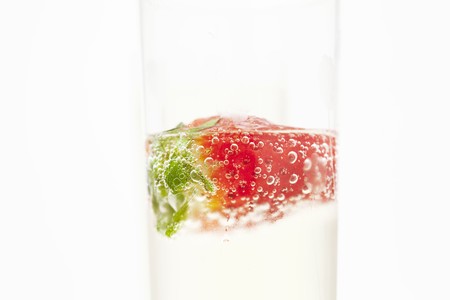 juicy strawberries and champagne glass isolated on whiteの写真素材