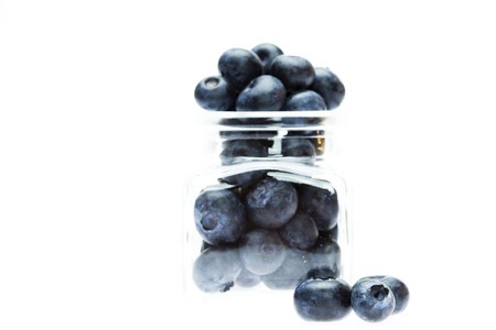 blueberries in a glass bottle isolated on whiteの写真素材