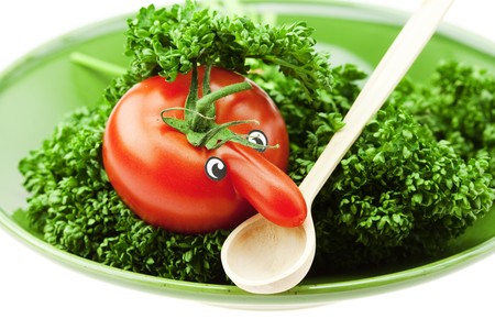 tomato with a nose on the plate and the green isolated on whiteの写真素材