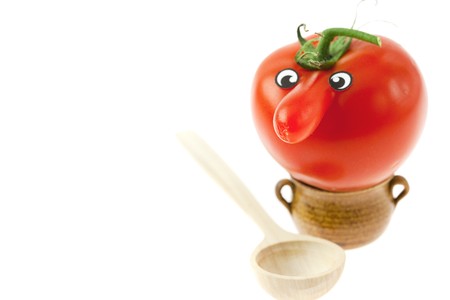 tomato with a nose and a small jug isolated on whiteの写真素材
