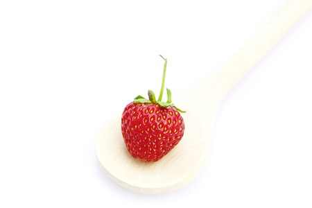 strawberry  in a wooden spoon isolated on whiteの写真素材