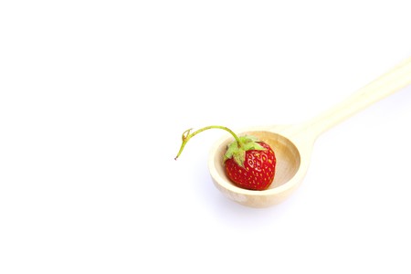 strawberry  in a wooden spoon isolated on whiteの写真素材