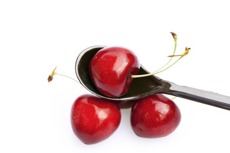 cherry  in a spoon isolated on whiteの写真素材
