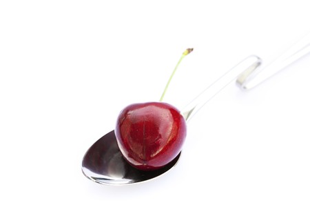 cherry  in a spoon isolated on whiteの写真素材