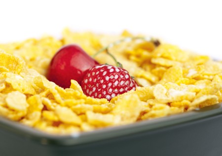 bowl of cornflakes milk  cherry  and strawberry  isolated on whiteの写真素材