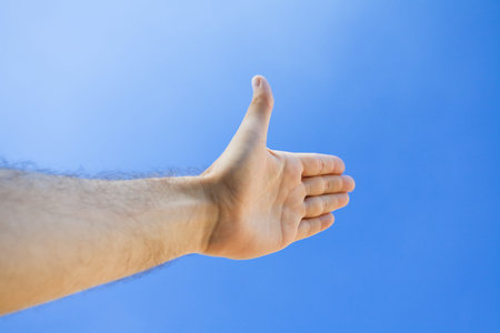 Hand against the blue skyの写真素材