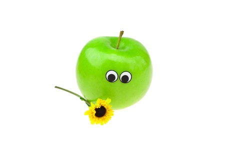 apples with eyes and faces and a flower isolated on whiteの写真素材