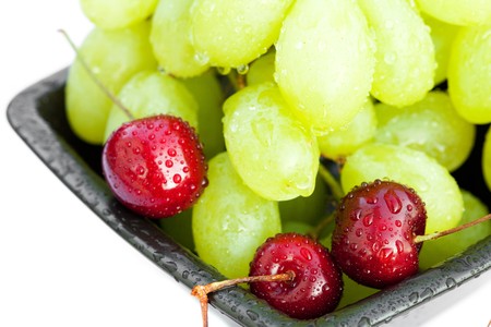 grapes cherry in the bowl is isolated on whiteの写真素材