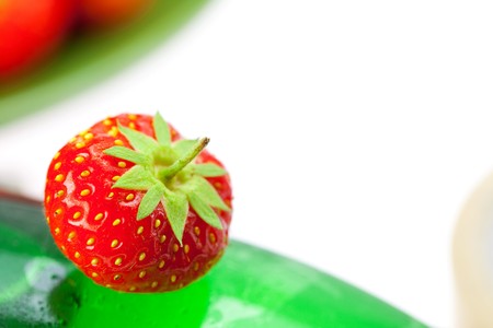 bottle of champagne with strawberries isolated on whiteの写真素材