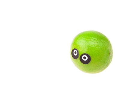 lime with eyes and faces isolated on whiteの写真素材
