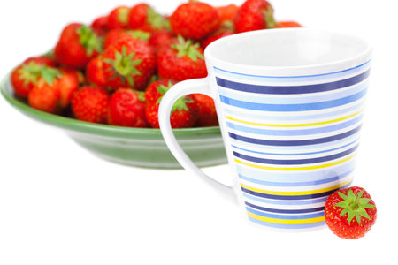 cup and saucer with strawberries isolated on whiteの写真素材