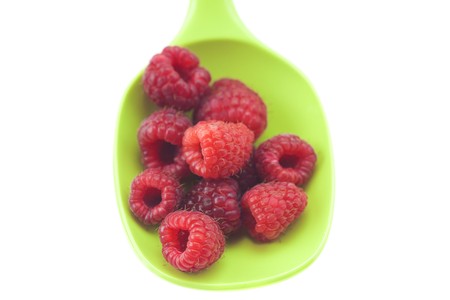 raspberries in a spoon isolated on whiteの写真素材