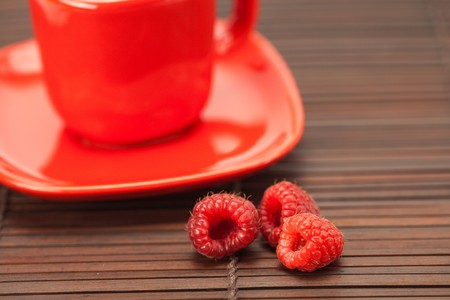Raspberry, cup with a plate on a bamboo matの写真素材
