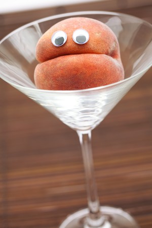 Peach with eyes in the glass martini on a bamboo matの写真素材