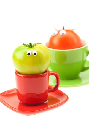 tomato with eyes in the cup isolated on whiteの写真素材