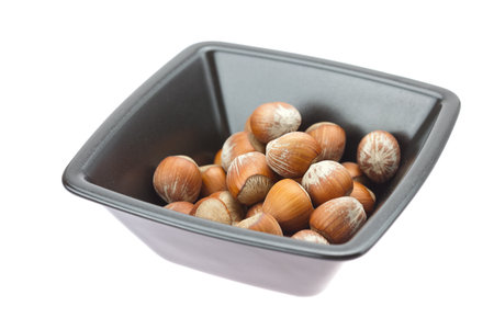 hazelnuts in a bowl isolated on white