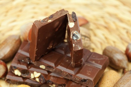 bar of chocolate and nuts on a wicker matの写真素材