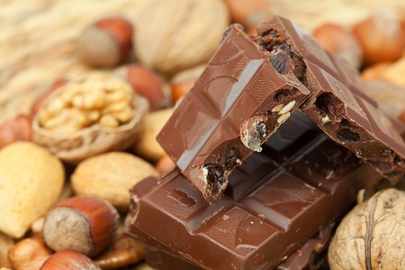 bar of chocolate and nuts on a wicker matの写真素材