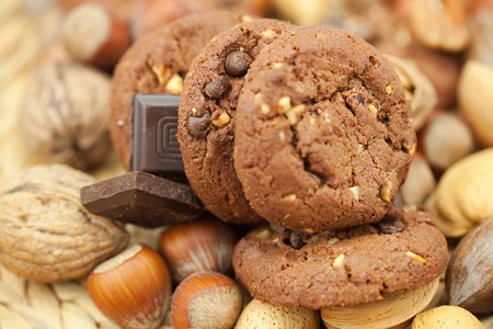 oatmeal cookies, chocolate and nuts on a wicker matの写真素材