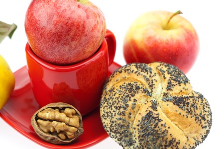 loaf with poppy seeds, quince, apples and walnuts in a cup and saucer isolated on whiteの写真素材
