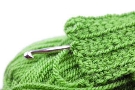 Skein of wool, crochet hook  and knitted piece isolated on whiteの写真素材