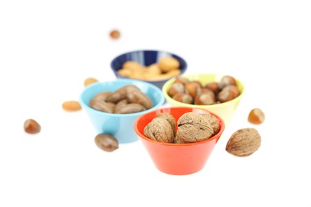nuts in bowls isolated on whiteの写真素材