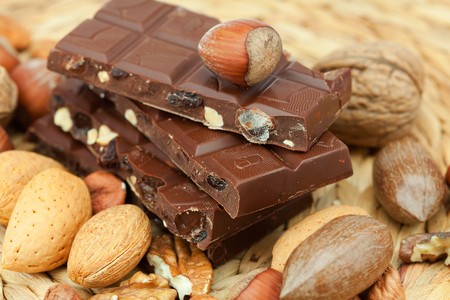 bar of chocolate and nuts on a wicker matの写真素材