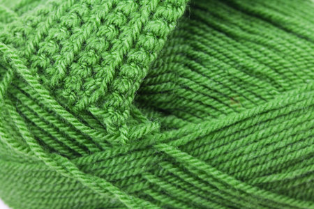 Skein of wool and knitted piece  background