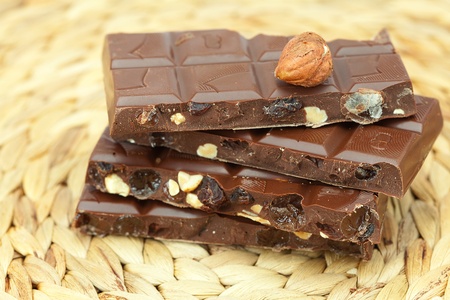 bar of chocolate and nuts on a wicker matの写真素材