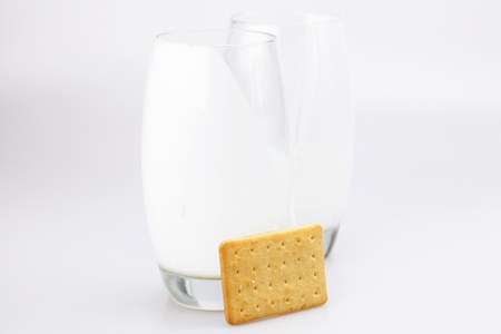 two glasses of milk and cookies on a gray backgroundの写真素材