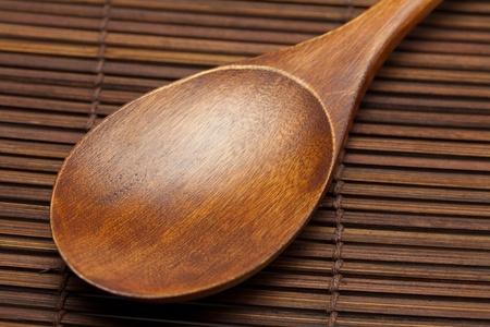 wooden spoon on a bamboo matの写真素材