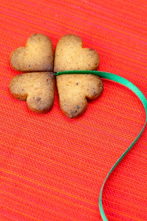 cookie  in the form of an Irish clover and green and green  on a red background      の写真素材