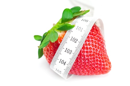 big juicy red ripe strawberries and measure tape isolated on whiteの写真素材