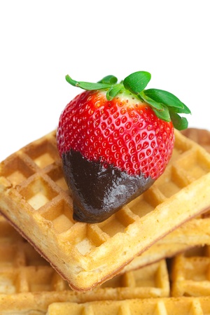 big juicy ripe strawberries in chocolate and waffles isolated on whiteの写真素材