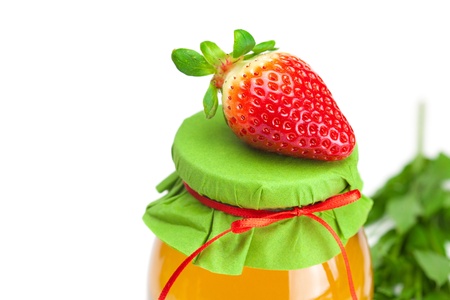 big juicy ripe strawberries  and  jar of honey  isolated on whiteの写真素材