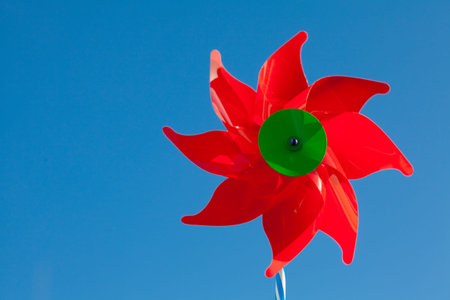toy red windmill against the blue sky