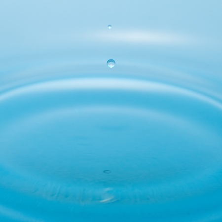 water drop and splash on a blue backgroundの写真素材